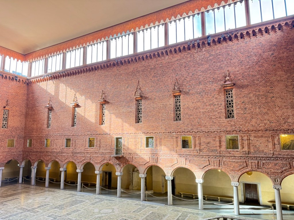 Interior view of Stockholm City Hall showcasing its beautiful brick walls and large windows, highlighting the architectural design.