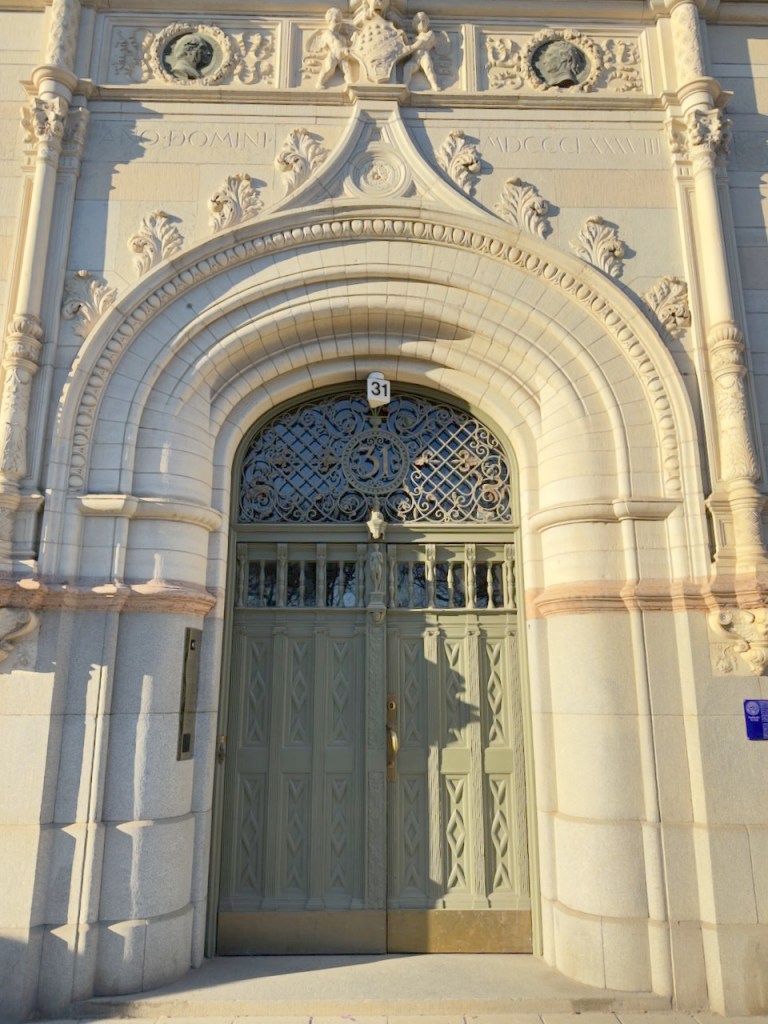 Intricate architectural details of a historic building entrance, featuring ornate stonework and decorative doors.