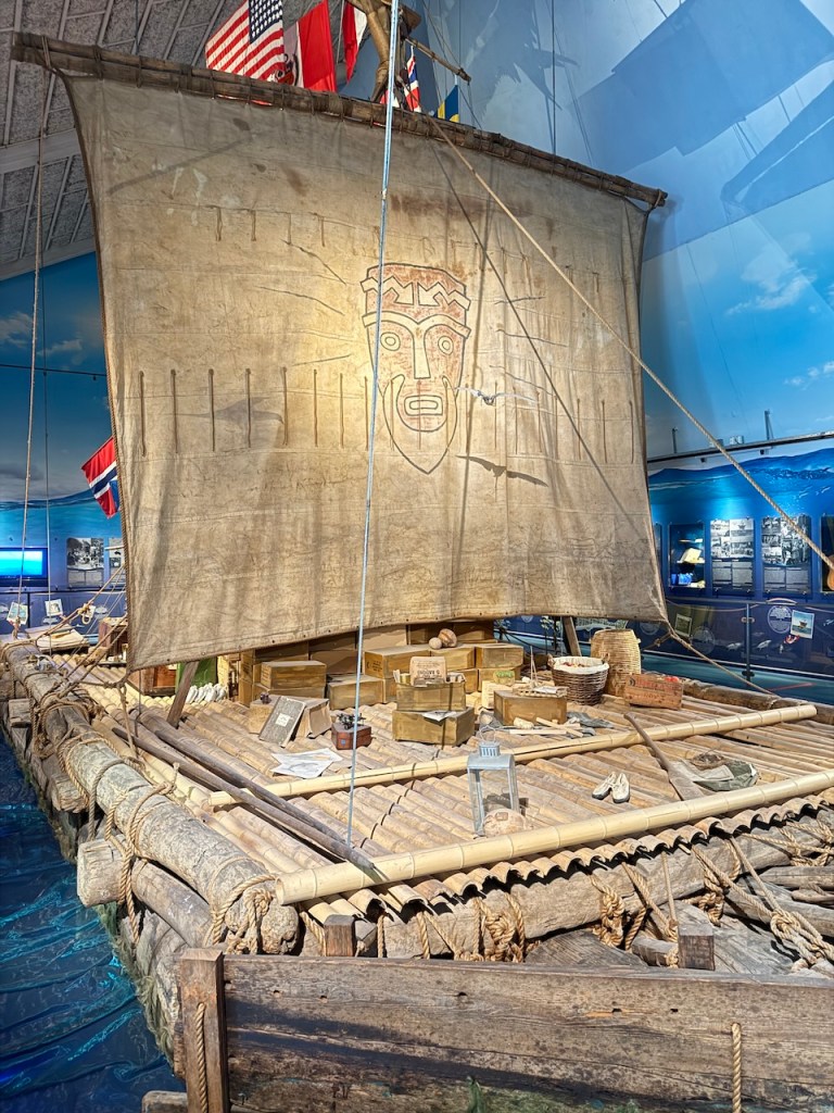 A model of the Kon-Tiki raft, displayed in the museum, with a sail and various artifacts around it.