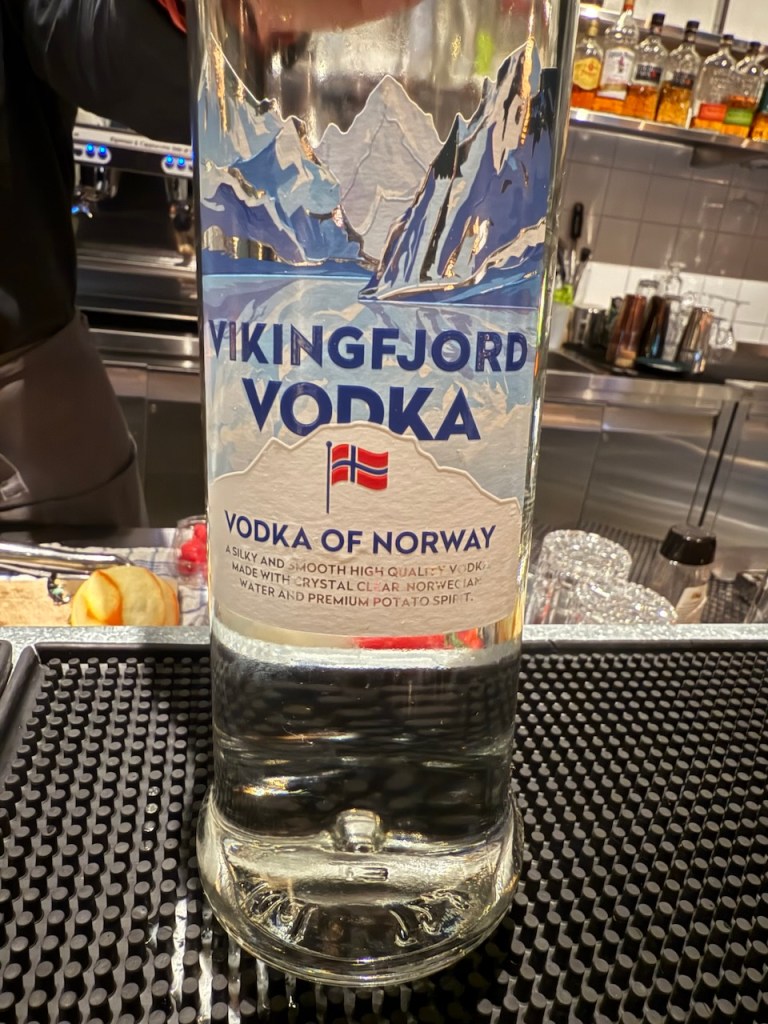 A close-up of a bottle of Vikingfjord Vodka, showcasing its label, which features snowy mountains and highlights its Norwegian origin.